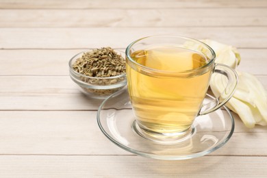 Photo of Aromatic fennel tea, seeds and fresh vegetable on wooden table, closeup. Space for text