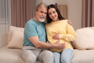 Photo of Father and his pregnant daughter indoors. Grandparents' reaction to future grandson