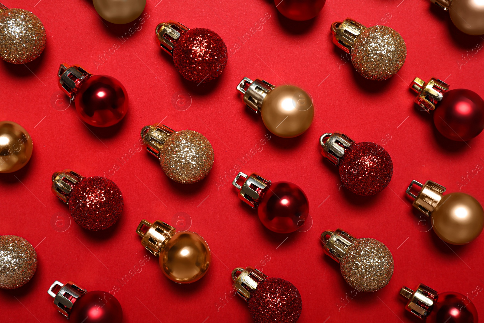 Photo of Colorful Christmas balls on red background, flat lay