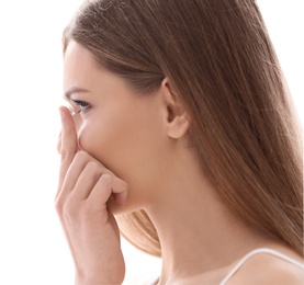 Young woman putting contact lens on white background