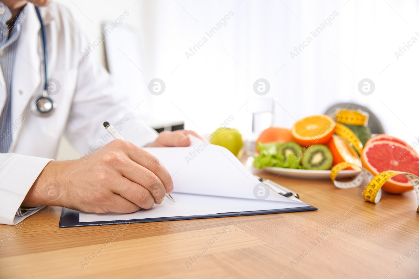 Photo of Nutritionist working at desk in office, closeup