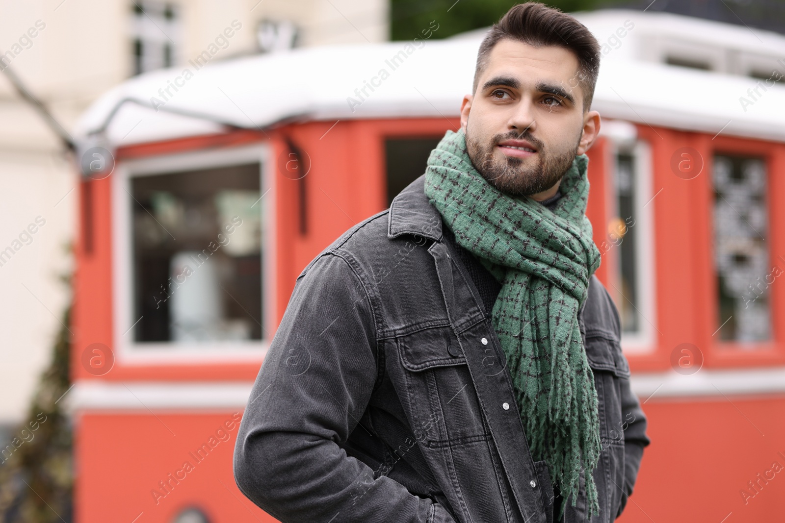 Photo of Handsome man in warm scarf outdoors. Space for text
