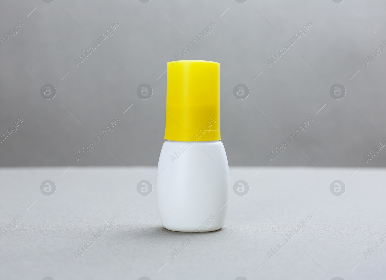 Photo of Bottle with insect repellent spray on grey background