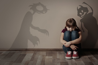 Image of Shadowsmonsters on wall and scared little girl in room