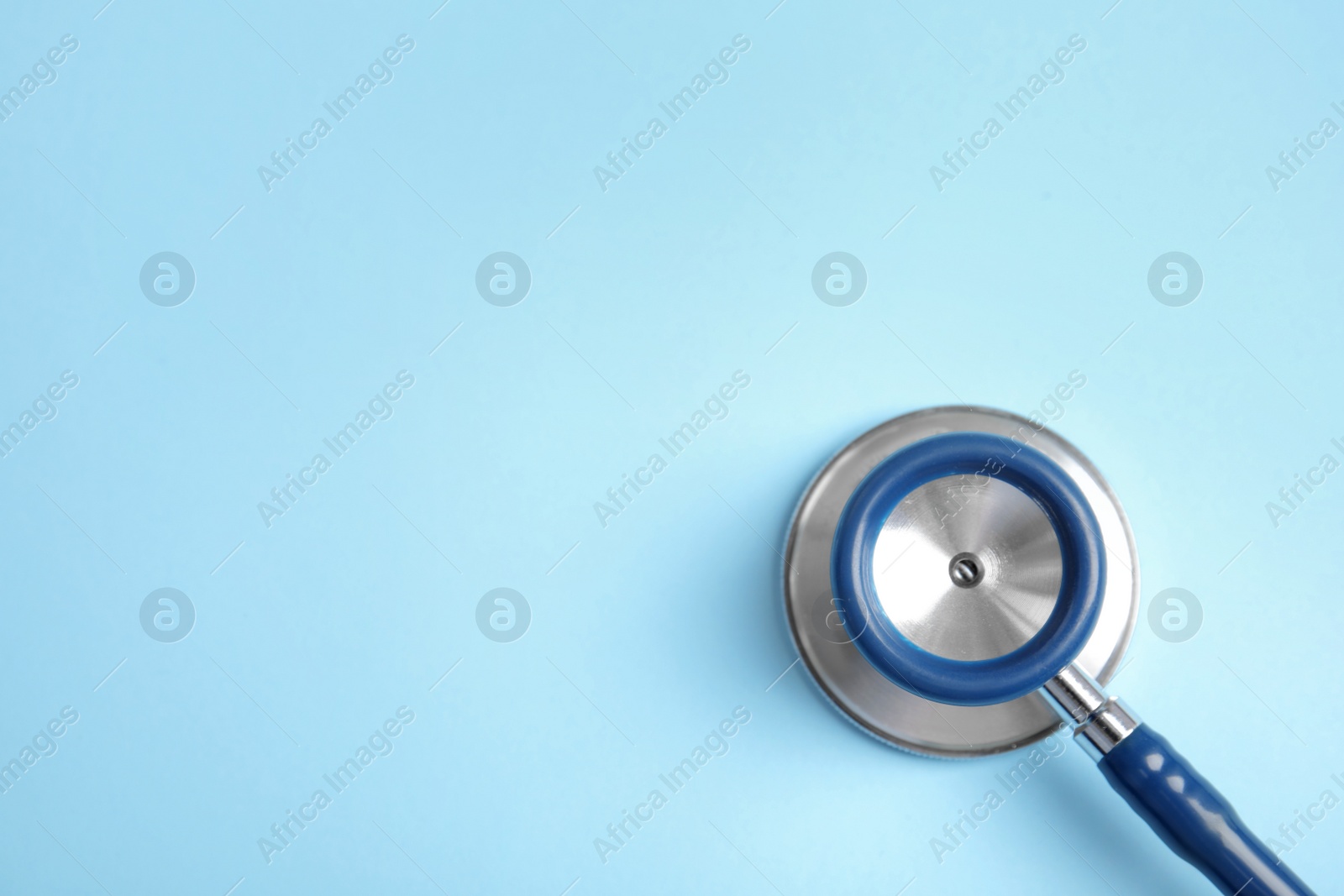 Photo of Stethoscope with space for text on color background, top view. Medical tool