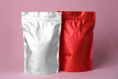 Photo of Different blank foil packages on pink background