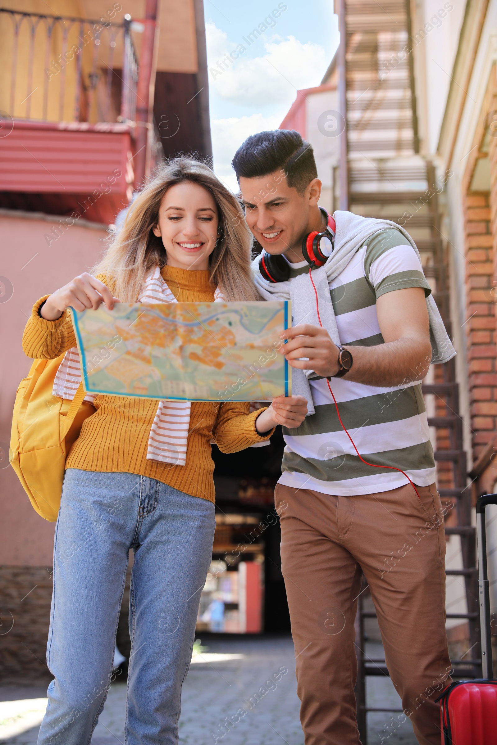 Photo of Couple of tourists with map on city street