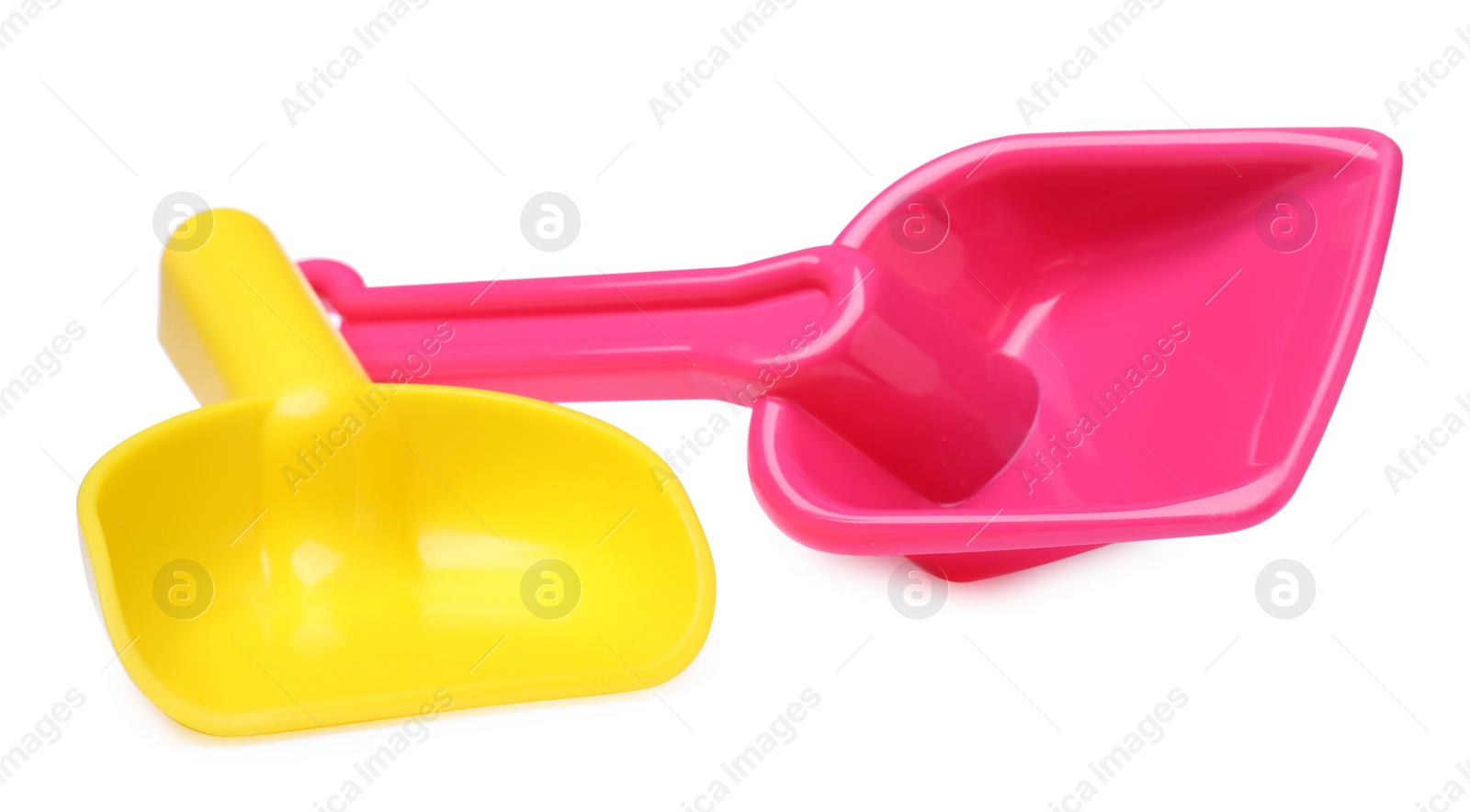 Photo of Yellow and pink plastic toy shovels on white background