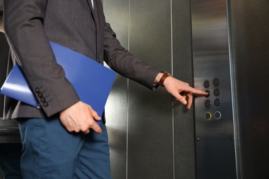 Photo of Man choosing floor in elevator, closeup view