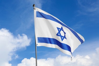 Image of National flag of Israel against blue sky with clouds