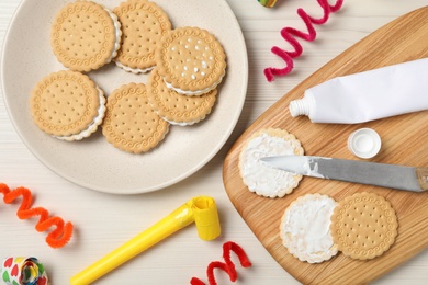 Photo of Cookies with toothpaste on white wooden table, flat lay. April fool's day