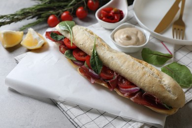 Photo of Delicious sandwich with bresaola served on light grey table