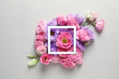 Photo of Beautiful Eustoma flowers and frame on gray background