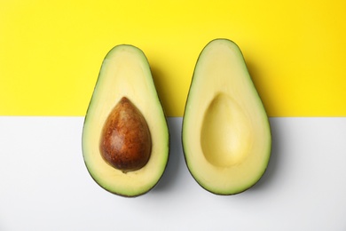 Photo of Cut fresh ripe avocado on color background, flat lay