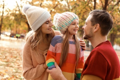 Happy family with child spending time together in park. Autumn walk
