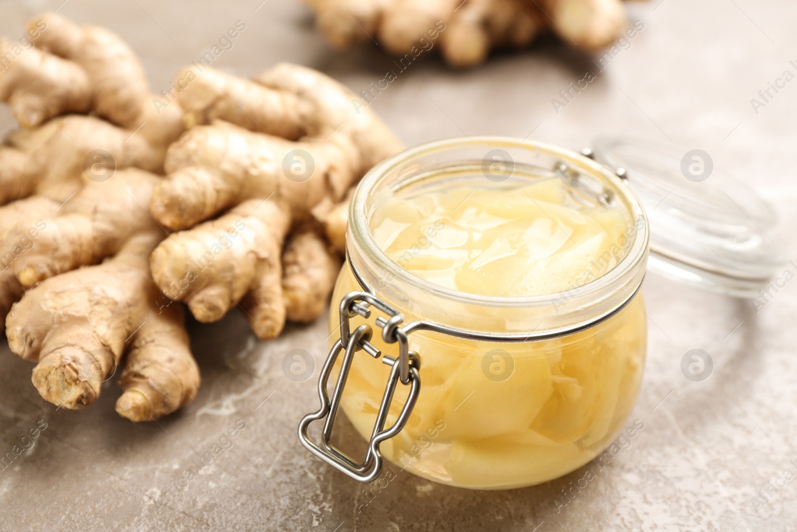 Photo of Spicy pickled ginger and root on grey table