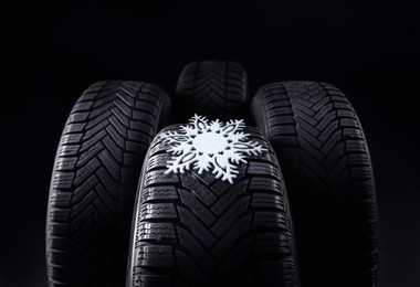 Image of Set of winter tires with snowflake on black background