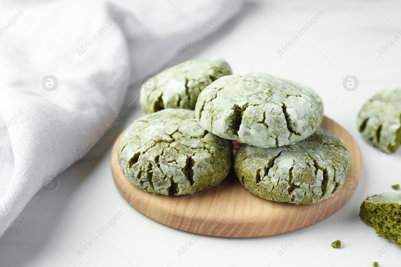 Photo of Board with tasty matcha cookies on white table, closeup. Space for text