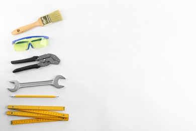 Photo of Flat lay composition with construction tools and goggles on white background. Space for text