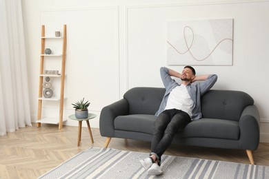 Handsome man relaxing on sofa at home