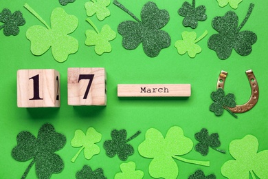 Flat lay composition with block calendar on green background. Saint Patrick's Day celebration