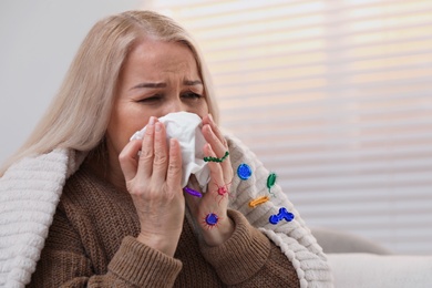 Image of Mature woman suffering from cold at home. Microbes spreading
