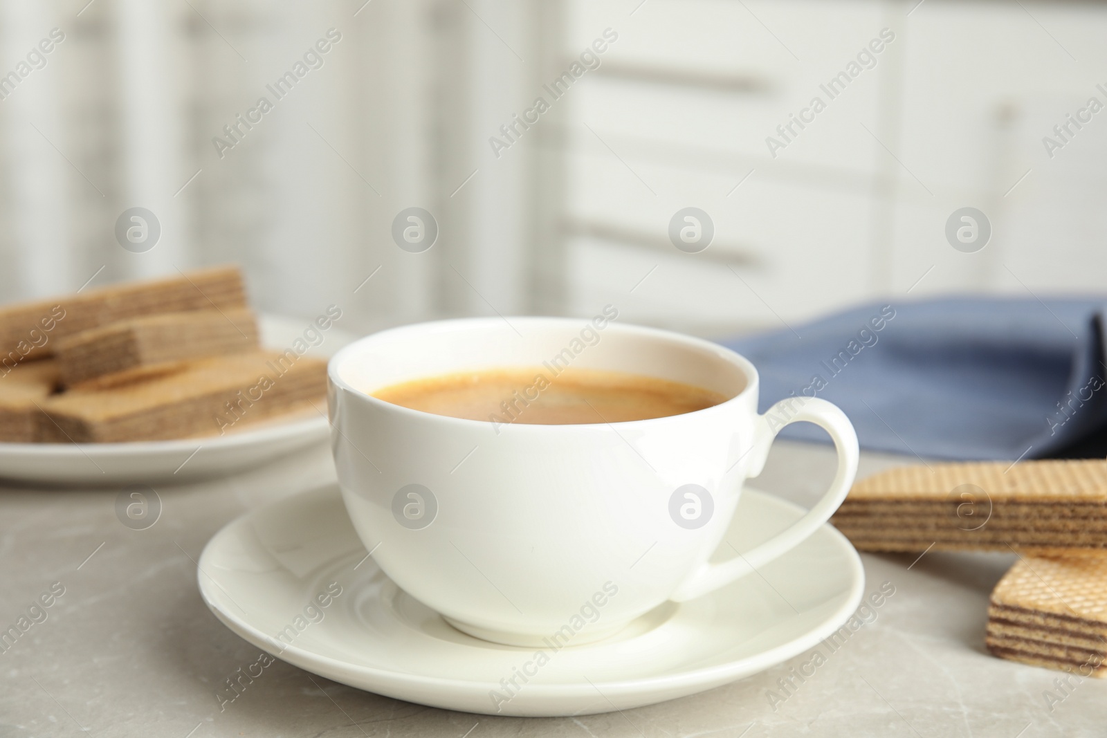 Photo of Delicious coffee and wafers for breakfast on grey marble table