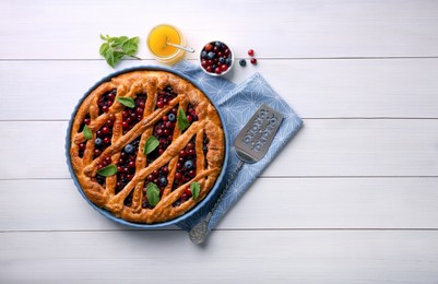 Photo of Delicious currant pie, honey and fresh berries on white wooden table, flat lay. Space for text