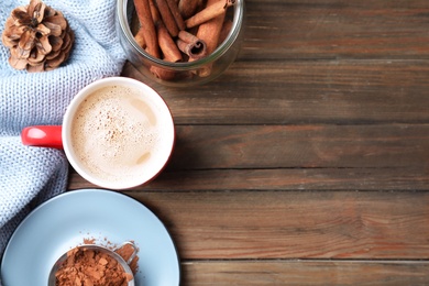 Flat lay composition with cup of tasty cocoa on wooden table. Space for text