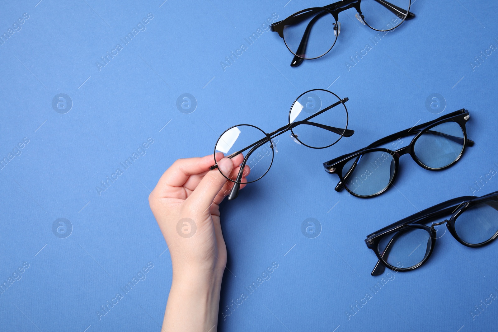 Photo of Woman with different stylish glasses on blue background, top view