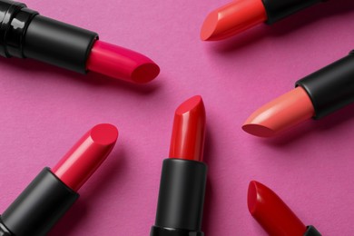 Photo of Beautiful lipsticks on pink background, flat lay