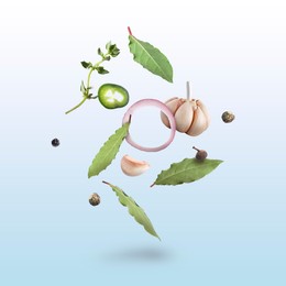 Image of Bay leaves, garlic, onion ring, thyme, black and fresh green peppers falling on light blue gradient background