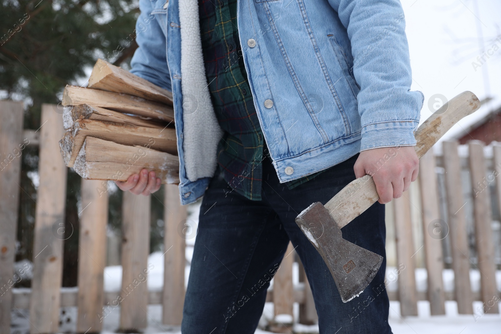 Photo of Man with axe and wood outdoors on winter day, closeup