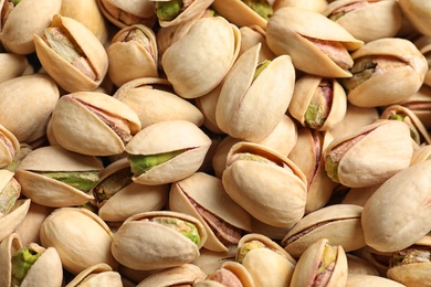 Photo of Organic pistachio nuts in shell as background, top view