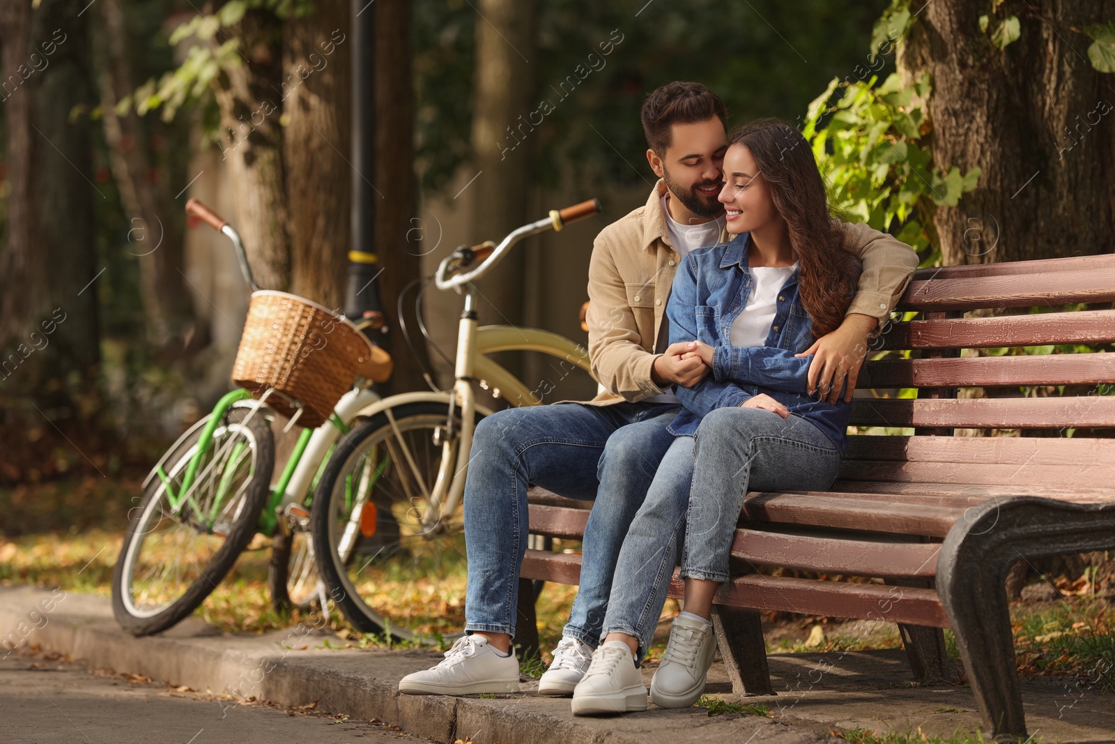 Photo of Beautiful couple spending time together in park, space for text