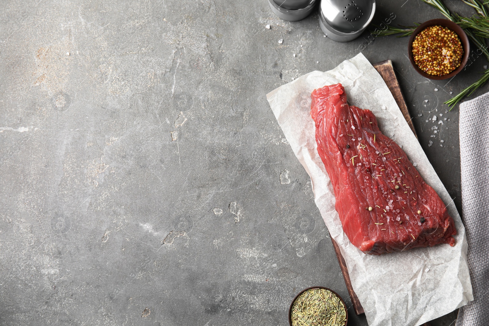 Photo of Flat lay composition with fresh beef cut on grey table. Space for text