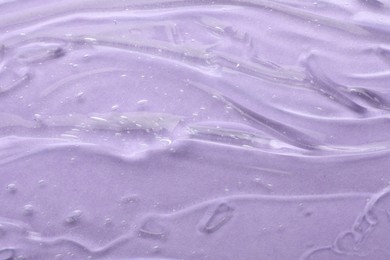 Clear cosmetic gel on violet background, top view