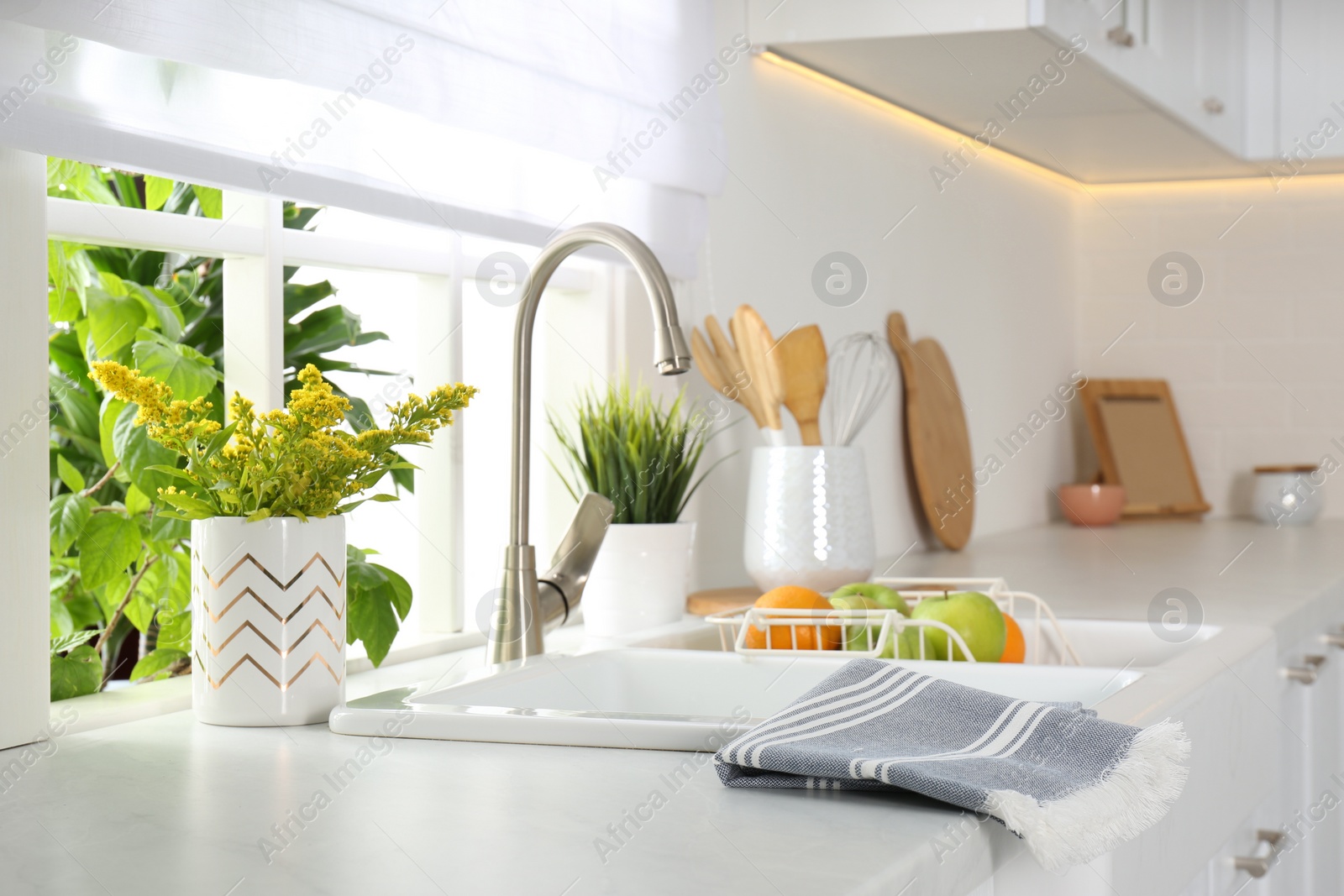 Photo of Beautiful white sink near window in modern kitchen