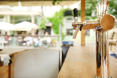 Bar counter with draft beer taps in open-air cafe