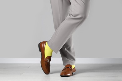 Photo of Man wearing stylish shoes and yellow socks indoors, closeup