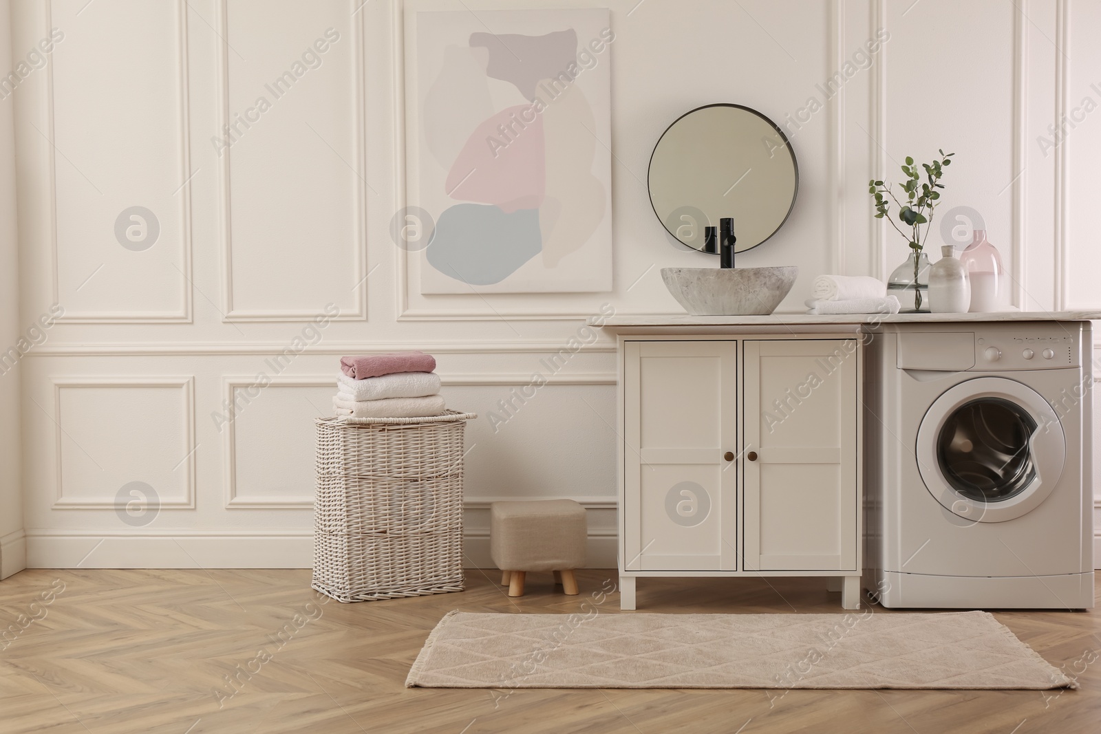 Photo of Laundry room interior with modern washing machine and stylish vessel sink on countertop