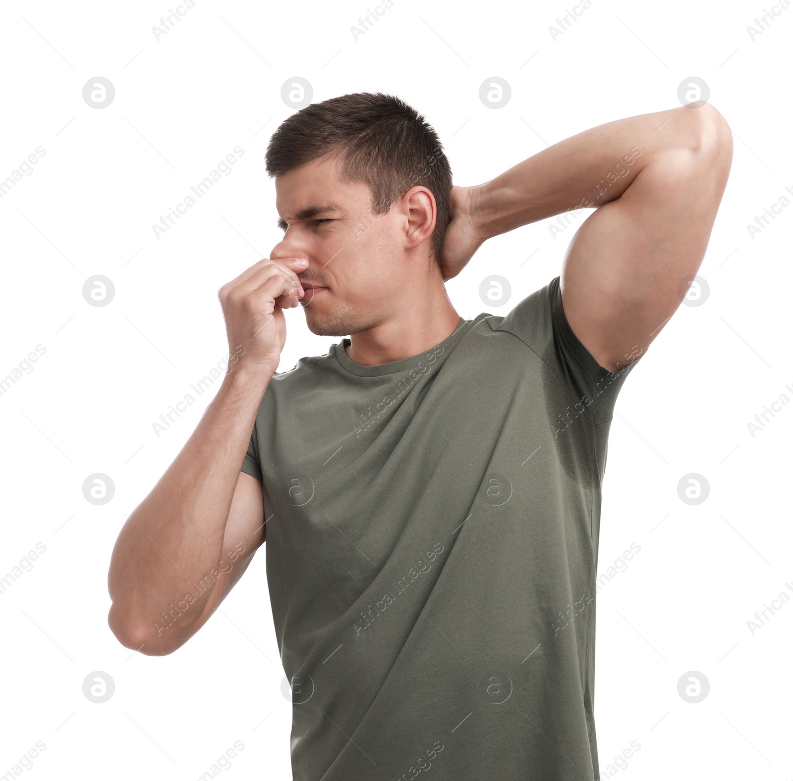 Photo of Young man with sweat stain on his clothes against white background. Using deodorant