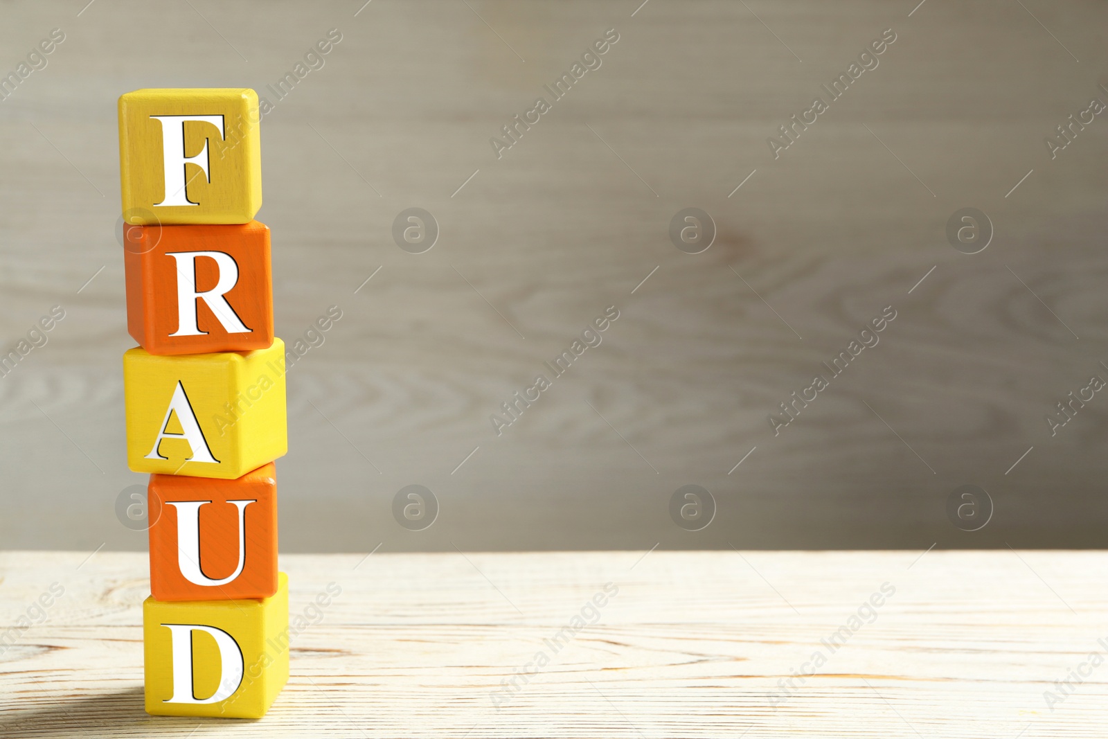 Photo of Word Fraud of cubes with letters on white wooden background. Space for text