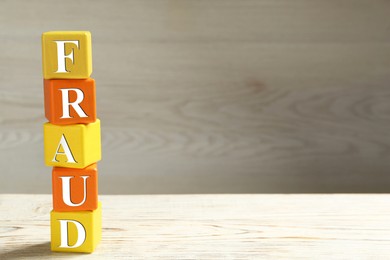 Word Fraud of cubes with letters on white wooden background. Space for text