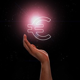 Image of Man demonstrating virtual euro sign on dark background, closeup