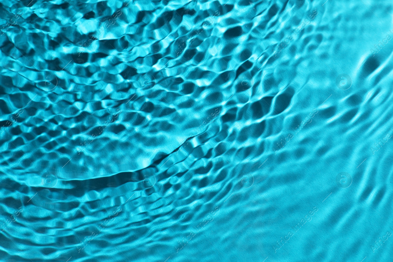 Photo of Rippled surface of clear water on light blue background, top view