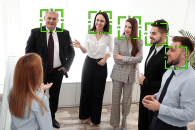 Image of Facial recognition system identifying people at business meeting