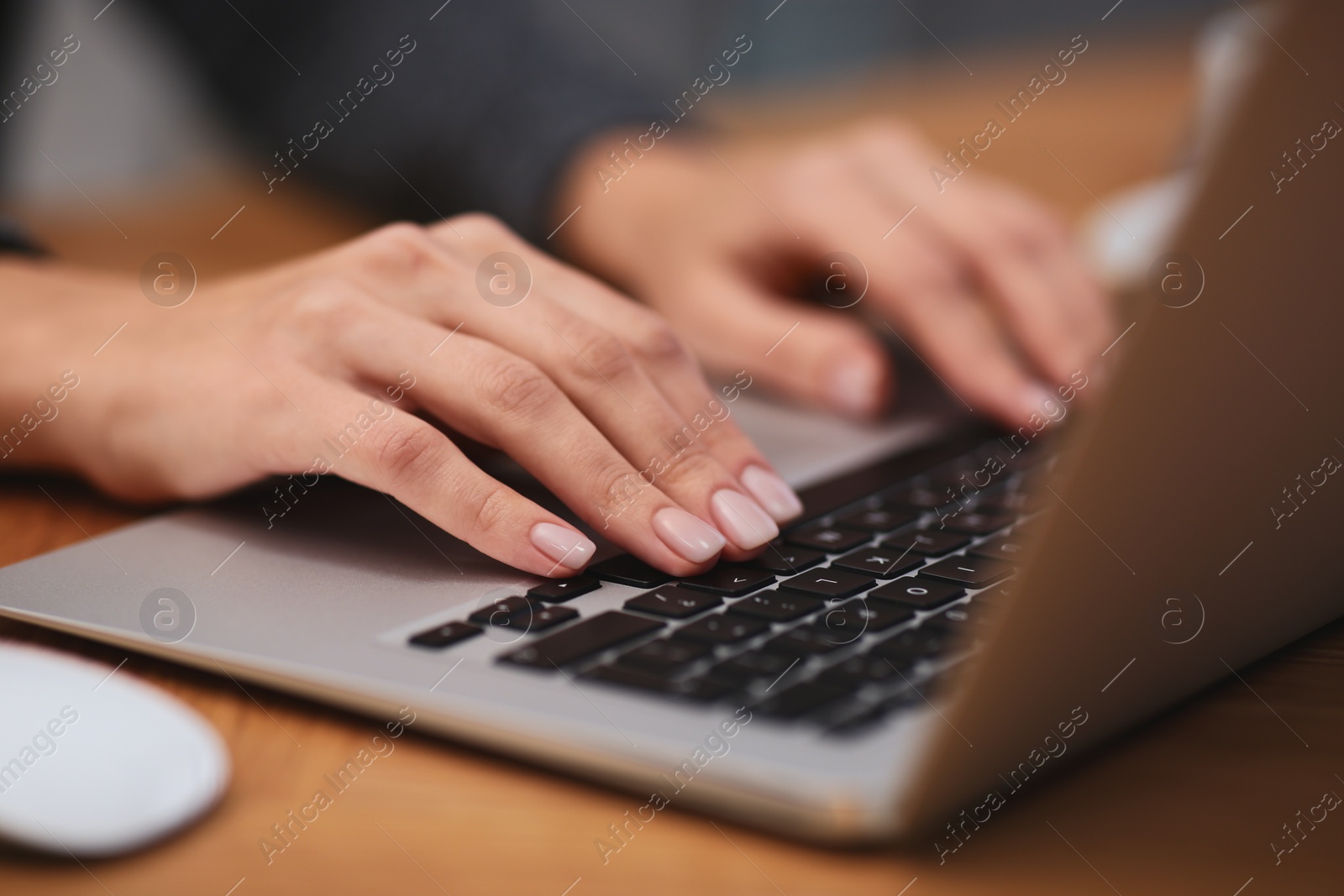 Photo of Woman working on modern laptop at table, closeup