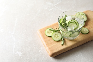Photo of Glass of fresh cucumber water on grey background. Space for text