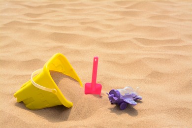 Photo of Set of colorful beach toys on sand. Space for text
